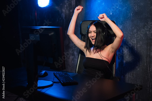 Portrait of a young happy girl who rejoices after winning a video game, - celebrating winning in gaming emotion concept.