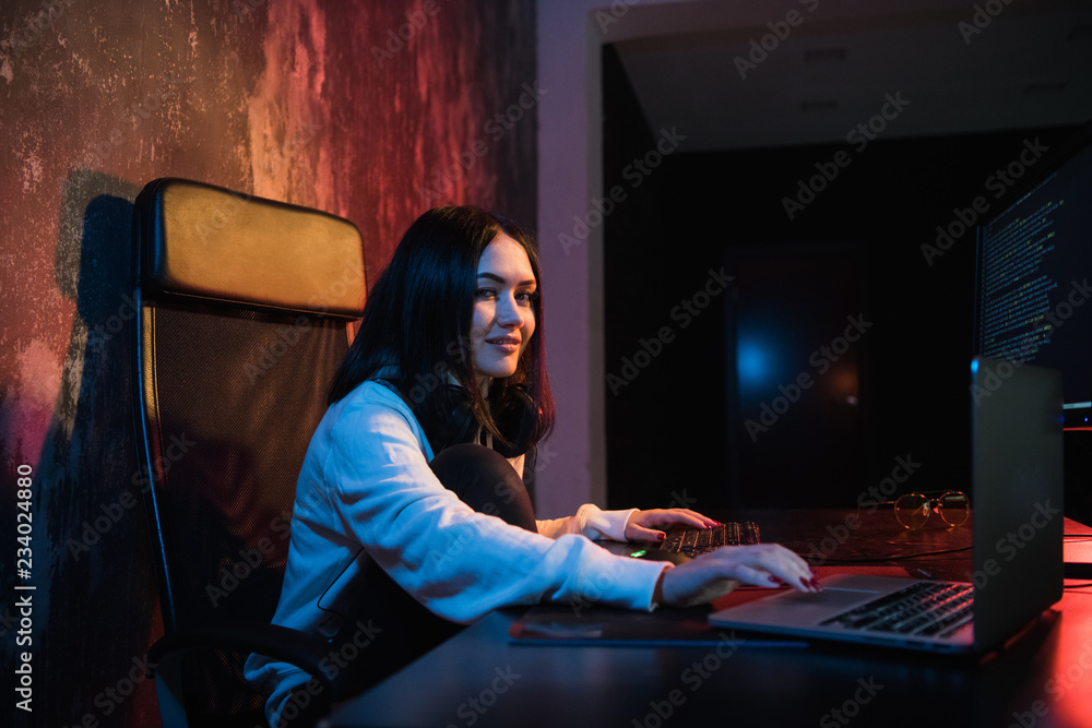 Young woman sit in front of personal computer and laptop, php Programming Html Coding Cyberspace Concept. Looking at camera Young woman sit in front of personal computer and laptop, php Programming Html Coding Cyberspace Concept. Looking at camera