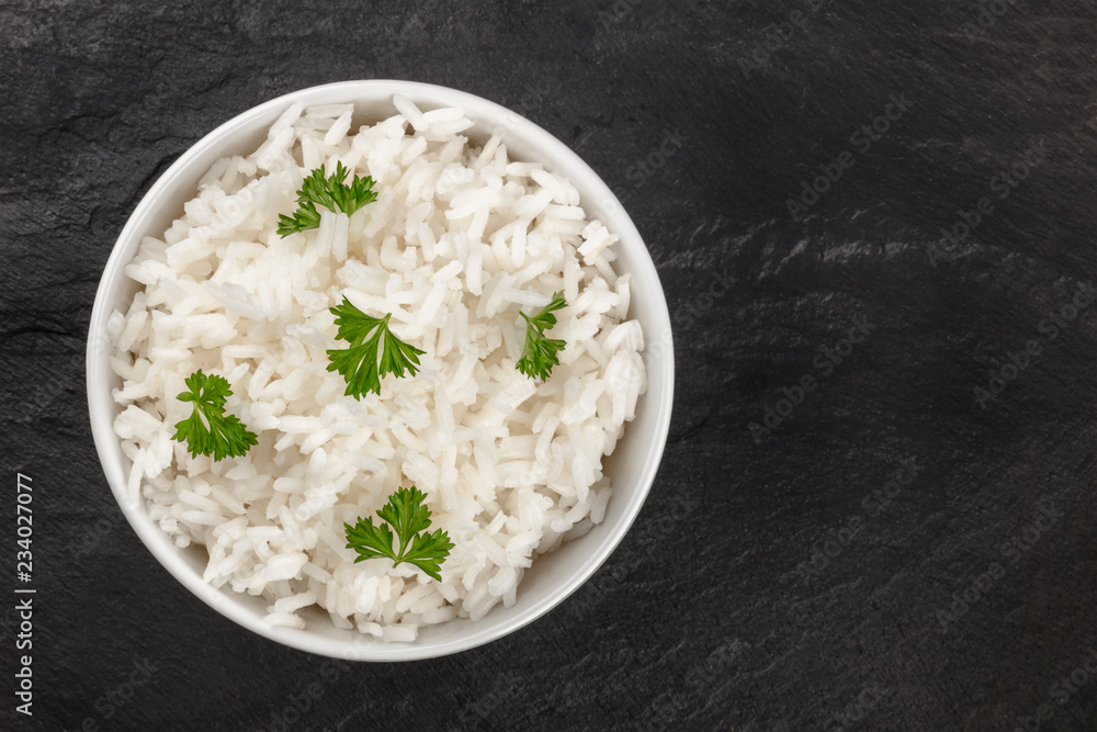A bowl of boiled white long rice, shot from the top on a black background with copy space A bowl of boiled white long rice, shot from the top on a black background with copy space