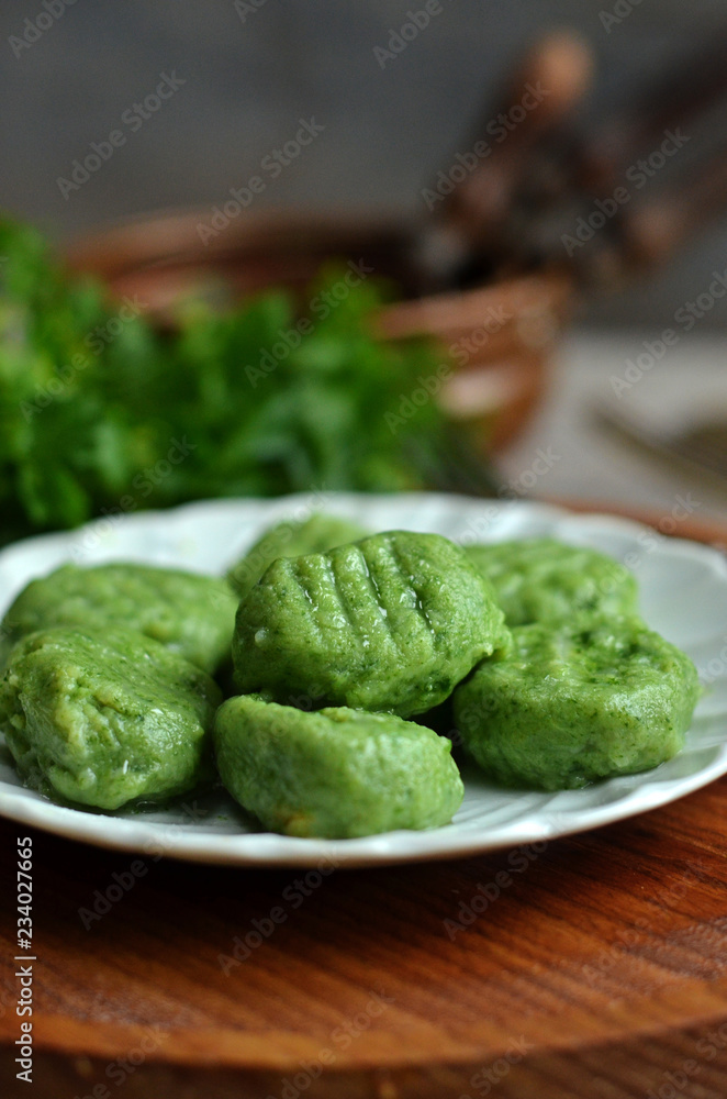 Green potato dumplings with spinach on a white plate Green potato dumplings with spinach on a white plate