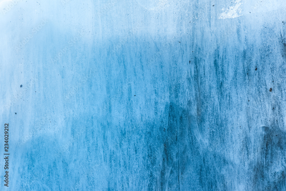 Close-up wall of a centuries-old glacier with a structure of stripes and bubbles. Ice blue light texture Close-up wall of a centuries-old glacier with a structure of stripes and bubbles. Ice blue light texture