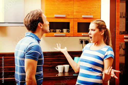 Young couple having quarrel in the kitchen photo