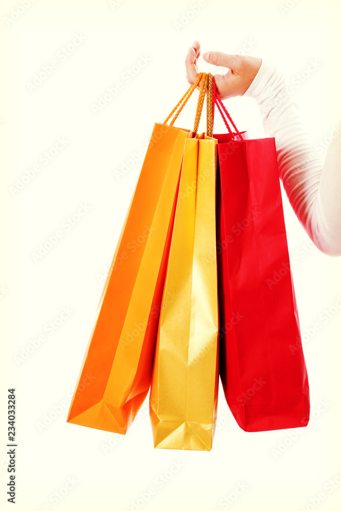 Isolated womans hand carries a shopping bag.