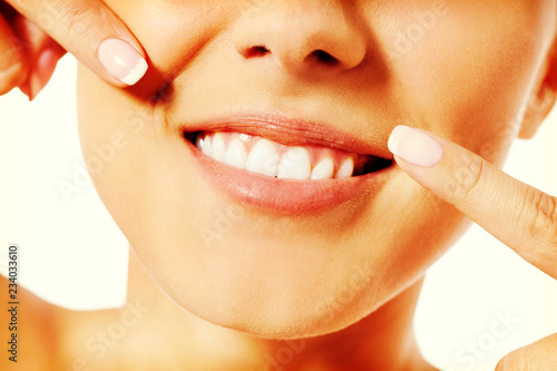 Dental health concept - beautiful woman pointing to her teeth