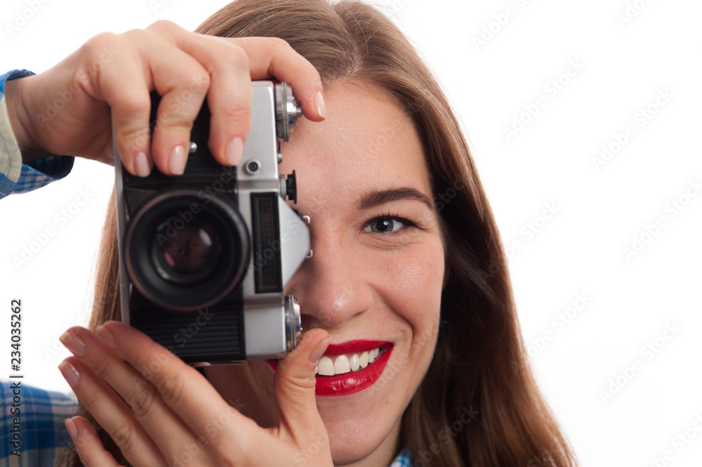 Close-up Portrait of young charming positive woman photographer with vintage camera in casual clothes on white background