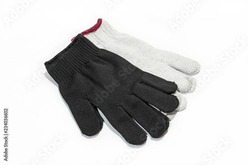 White and black cloth gloves for hand wear on white floor.