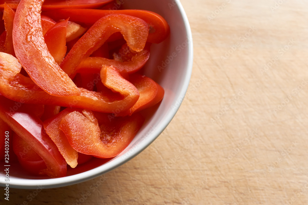 Close-up of a bowl of freshly cut juicy paprika or bell pepper on a wooden background with copy space Close-up of a bowl of freshly cut juicy paprika or bell pepper on a wooden background with copy space
