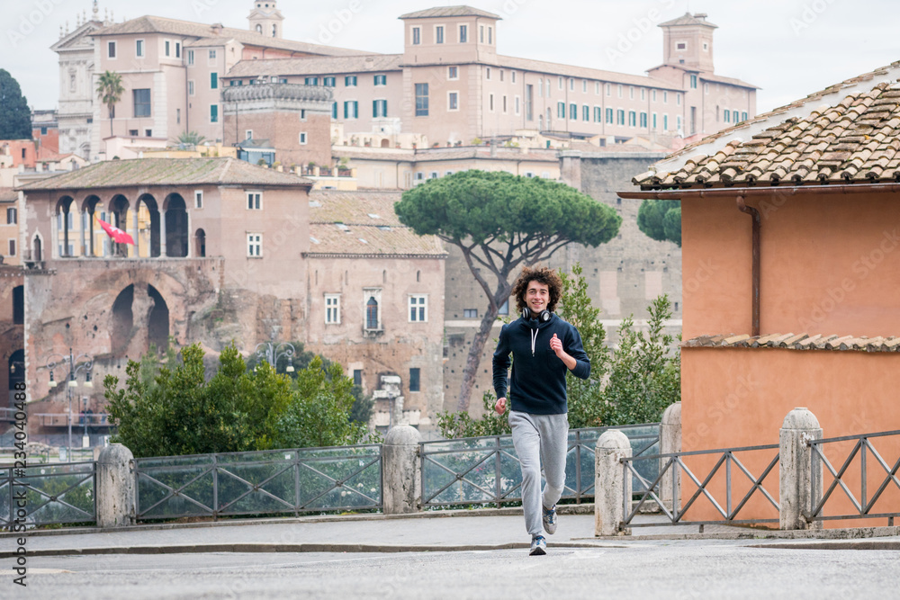 Handsome young sportsman jogging in Rome city