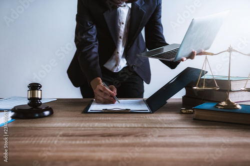 Lawyer or business woman using laptop with contact papers on table in office. wooden gavel justice and law ,attorney, court judge, concept.