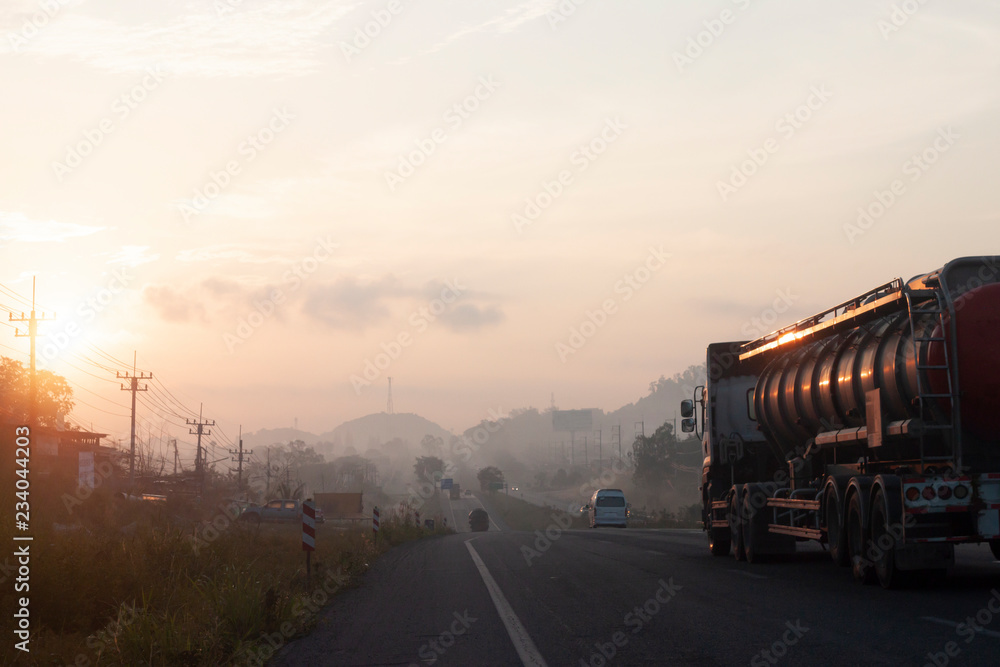 The journey of the vehicle in the morning on highway with Morning sun and fog.