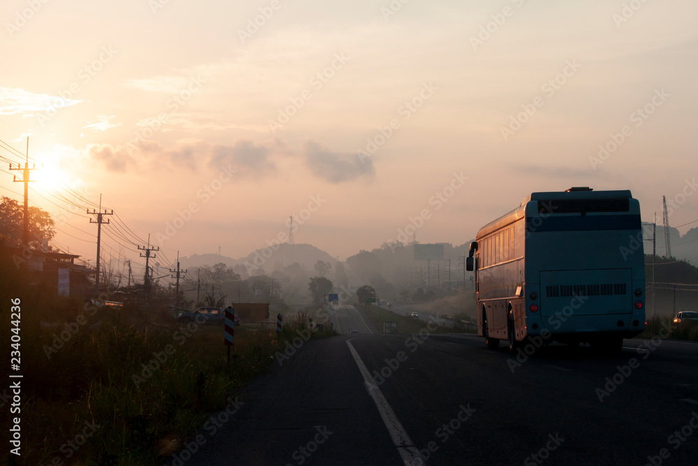 The journey of the vehicle in the morning on highway with Morning sun and fog.