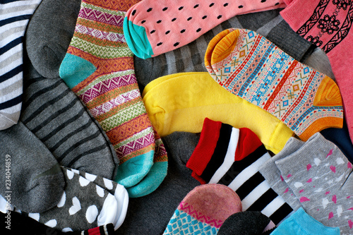 A pile of multi-colored socks. View from above. Many colorful socks form a textural background. Socks of different types and sizes.