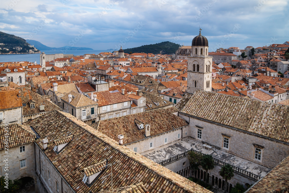 Panorama view of the mediterranean old town of Dubrovnik Franciscan monastery with orange tiled roofs and view on ocean and island Lokrum, Croatia