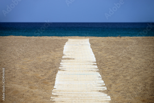 Wooden path over the sand of Spiaggia della Piscinas beach  Sardinia island  Italy