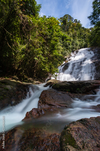 Long exposure of a picturesque waterfall flowing through a tropical rainforest