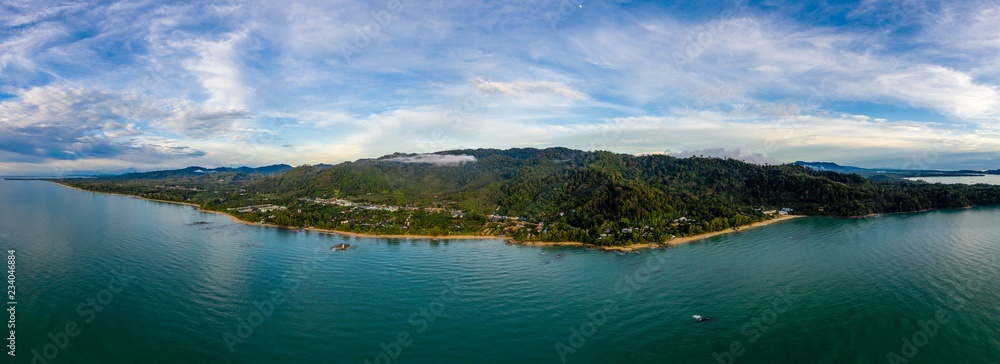 Aerial panoramic view of a tropical beach, jungle and town at sunset (Khao Lak, Thailand)