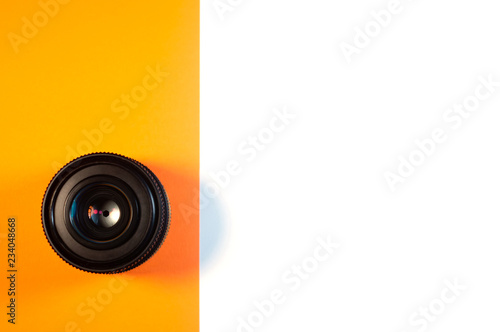 Lens on orange and white background isolated