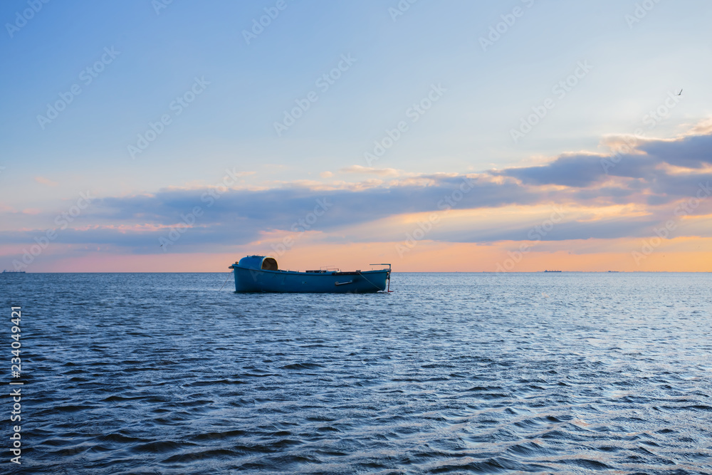 small boat silhouette among a sea at the sunset small boat silhouette among a sea at the sunset