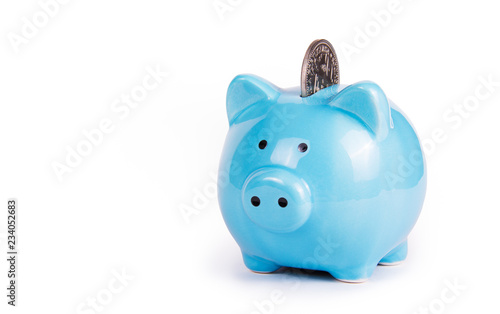 Blue piggy bank on white background. Copy space. Piggy bank and coin. Symbol of the year 2019