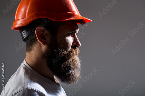 Portrait architect builder, civil engineer working. Builder in hard hat, foreman or repairman in the helmet. Bearded man worker with beard in building helmet or hard hat. Man builders, industry.