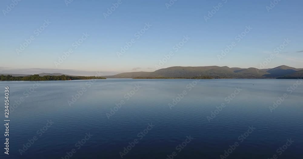 Inspiring and mystic aerial view from a drone of Loch Lomond in Scotland - Summer time with blue sky Inspiring and mystic aerial view from a drone of Loch Lomond in Scotland - Summer time with blue sky
