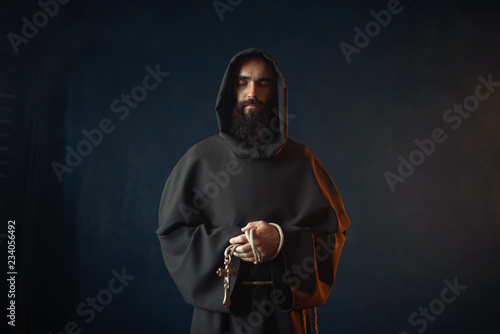 Fotografie Medieval monk holds cross in hands and praying
