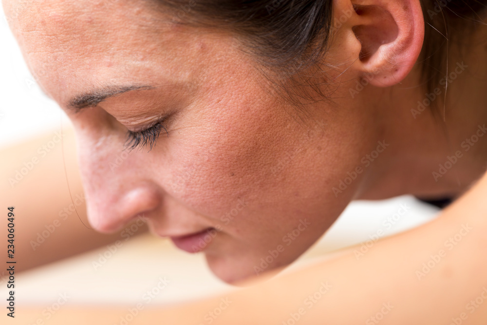 Close-up side view of a young woman on a seated / forward bend or Sleeping Swan asana or yoga pose. Close-up side view of a young woman on a seated / forward bend or Sleeping Swan asana or yoga pose.