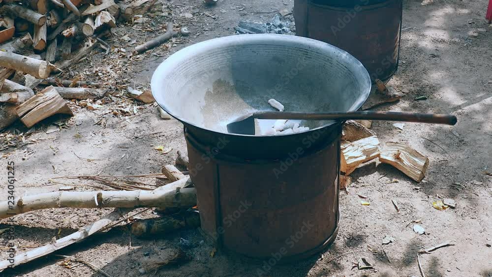 Stir-frying cuts of pork in a wok on a large charcoal and wood brazier stove outdoors (close-up) Stir-frying cuts of pork in a wok on a large charcoal and wood brazier stove outdoors (close-up)