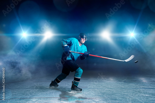 Hockey player with stick and puck makes a throw