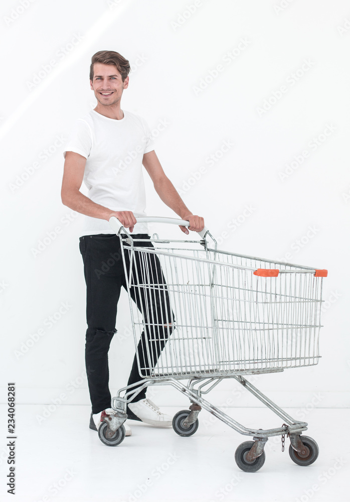 young man pushes an empty shopping cart young man pushes an empty shopping cart