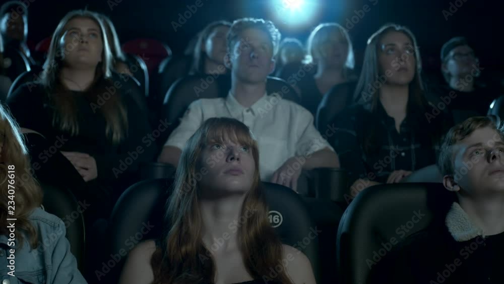 Teenage audience watching a movie at the cinema Teenage audience watching a movie at the cinema