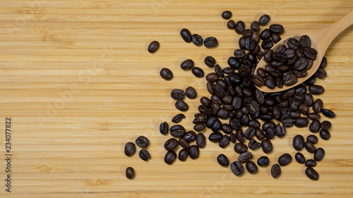 Coffee beans with wooden spoon on wood table background. Top view