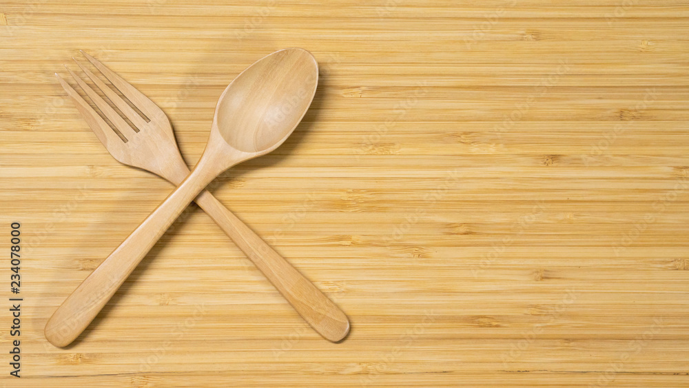 Wooden spoon and fork on wood table background. Top view. Eating food in the restaurant concept Wooden spoon and fork on wood table background. Top view. Eating food in the restaurant concept