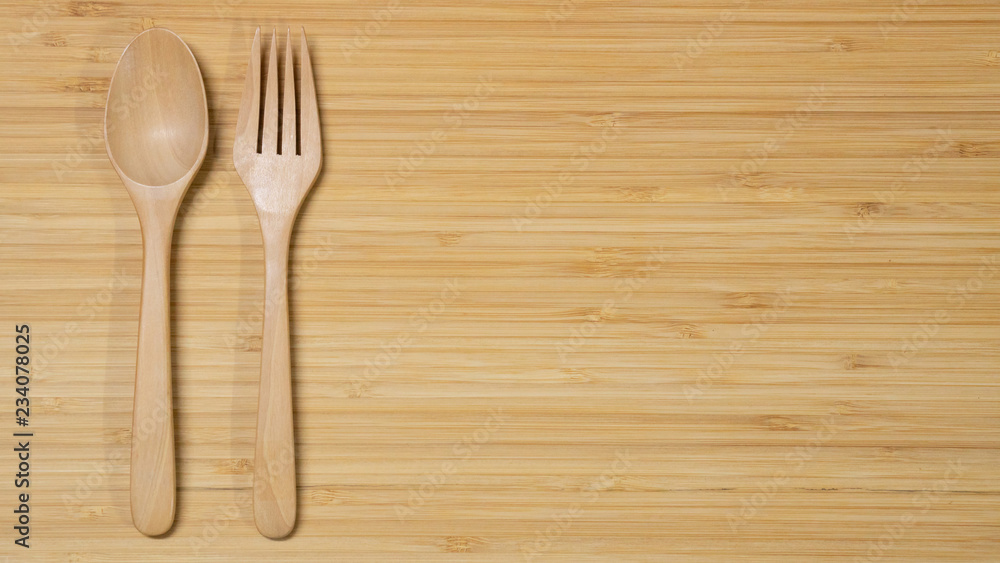 Wooden spoon and fork on wood table background. Top view. Eating food in the restaurant concept Wooden spoon and fork on wood table background. Top view. Eating food in the restaurant concept