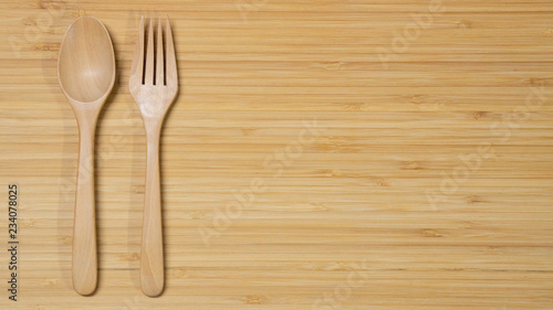 Wooden spoon and fork on wood table background. Top view. Eating food in the restaurant concept
