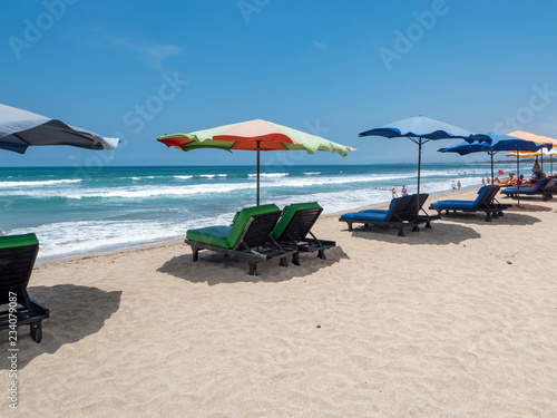 White sand and blue ocean. Various colorful beach umbrellas and pillows in Kuta  Bali. October  2018