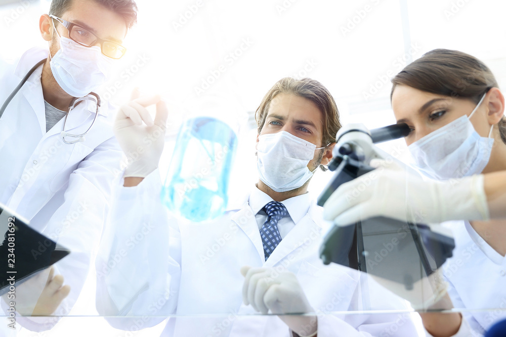young scientists working with a microscope and test tubes young scientists working with a microscope and test tubes