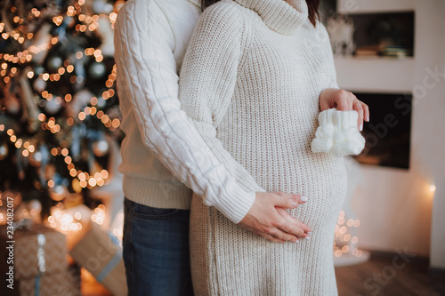 Happy parents pregnant woman heart symbol love husband touching tummy new year or christmas background