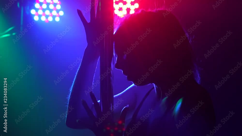 Sexy girl spinning around a pole in a dark room in slow motion. Pole