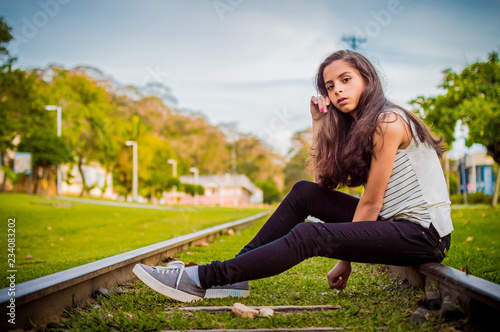 Photography Pretty brown-haired girl in black jeans sitting on railway track