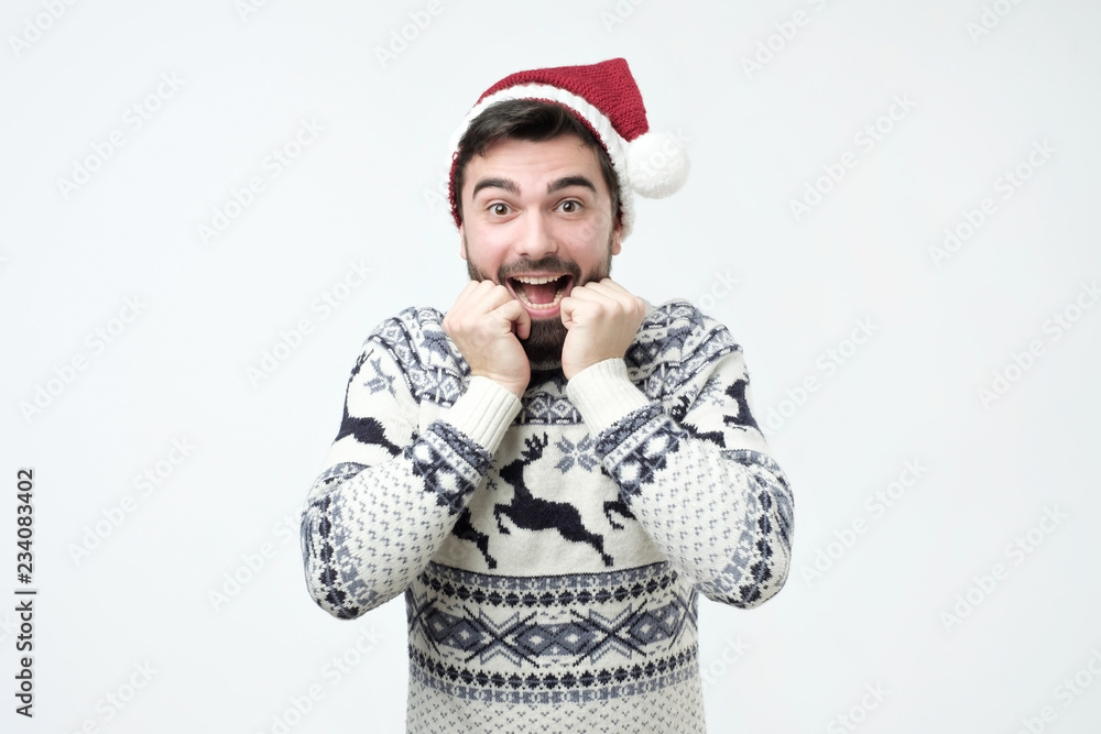 Happy hispanic man in Santa Claus cap is excited and happy. Happy hispanic man in Santa Claus cap is excited and happy.