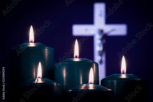 Lit candles on a white cross