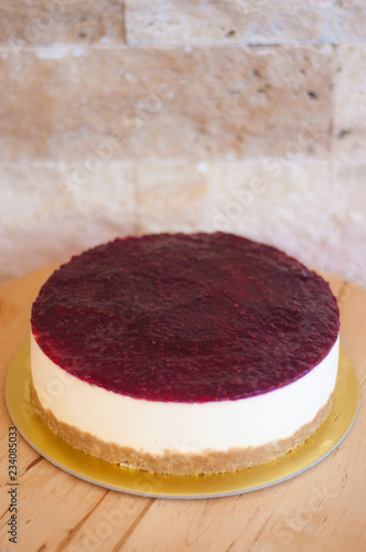 Raspberry cheesecake on wooden table
