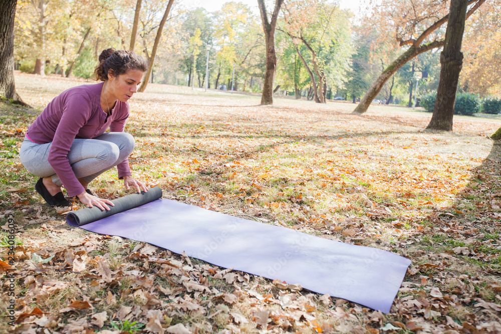 Fit Woman Prepare For Exercise Rolling Yoga Mat At Park Fit Woman Prepare For Exercise Rolling Yoga Mat At Park