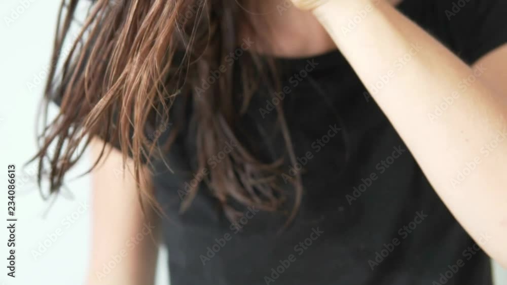 Woman slowly combing wet hair with a wooden hairbrush. She leads the comb from top to bottom. Close-up. Beautiful, healthy hair Woman slowly combing wet hair with a wooden hairbrush. She leads the comb from top to bottom. Close-up. Beautiful, healthy hair