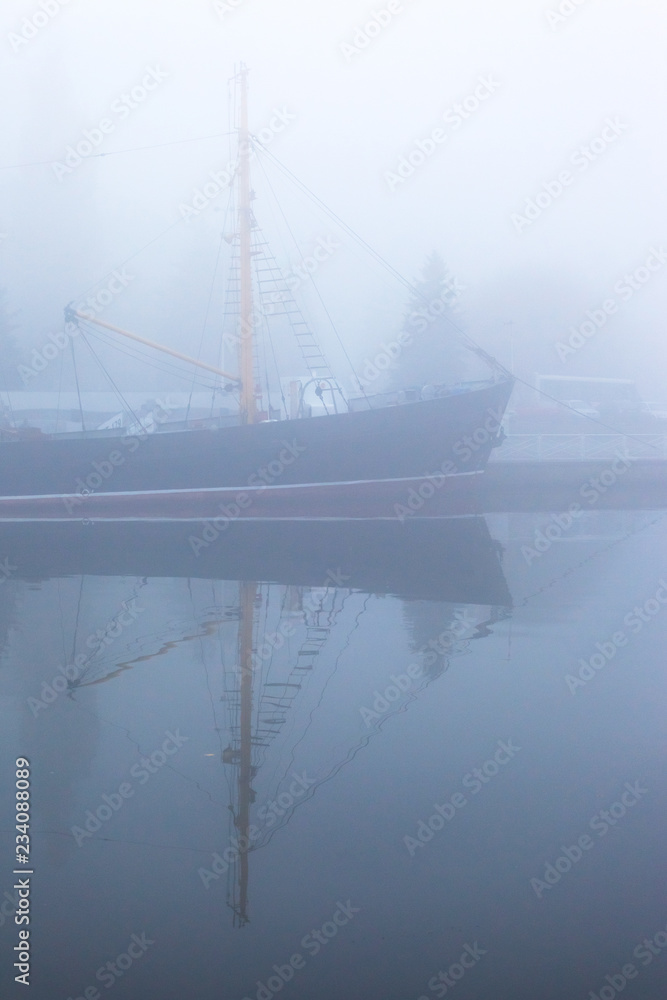 Fototapeta premium ship at the pier on the river in a thick dense fog