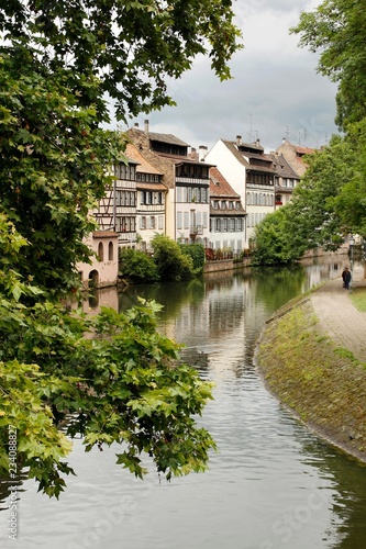 Typical european midieval town with houses, canal, trees and food path
