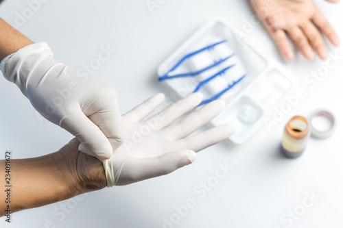 Woman doctor hands wearing gloves to clean the wound on the boy's palm