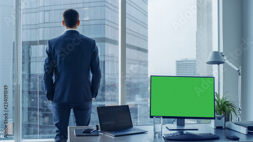 Quadro em tela Confident Businessman in a Suit Contemplating Business Deal in His Office, Looking out of the Window