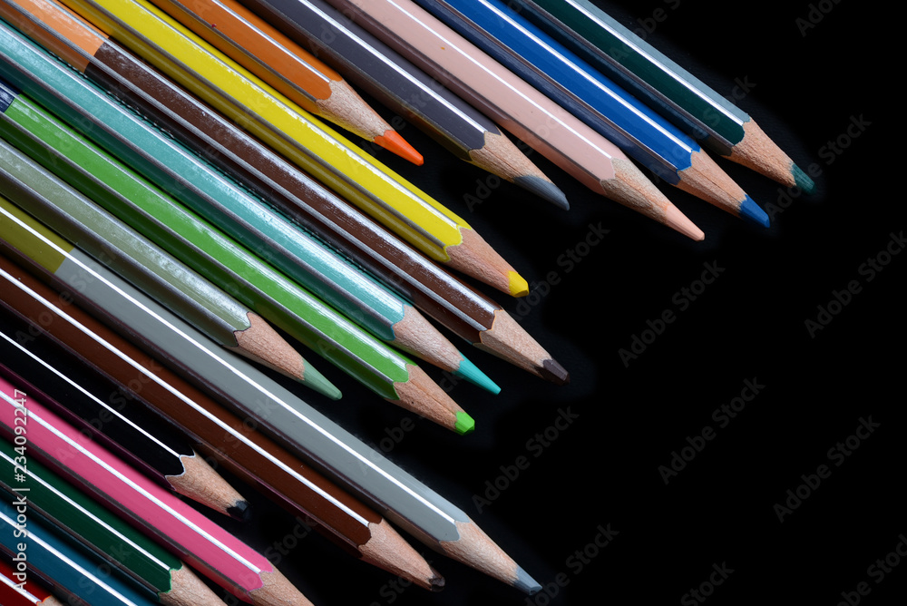Fototapeta premium A pack of multicolored pencils on a dark background close up